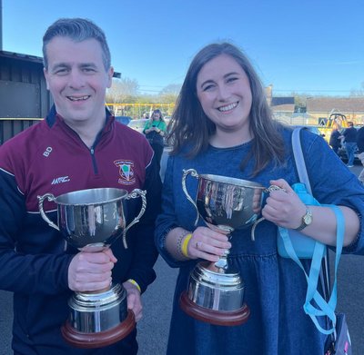 Pictured with the Leinster Final cups: Brendan Doyle (CLG Rath Éanna) and Aoife Nic Uidhir (CLG Scoil Uí Chonaill). Image